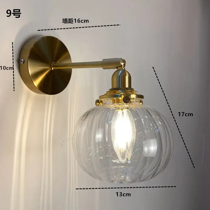 Modern brass ruffled clear glass led wall sconce featuring a brass finish and decorbites clear glass with exposed filament bulb