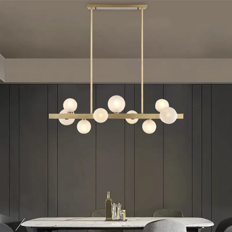 Modern brass simplicity globe pendant with frosted glass bulbs in a linear design for dining room lighting