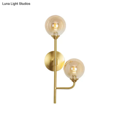 Modern brass sphere wall sconce with two amber smoke gray glass bulbs for bathroom lighting in brass finish