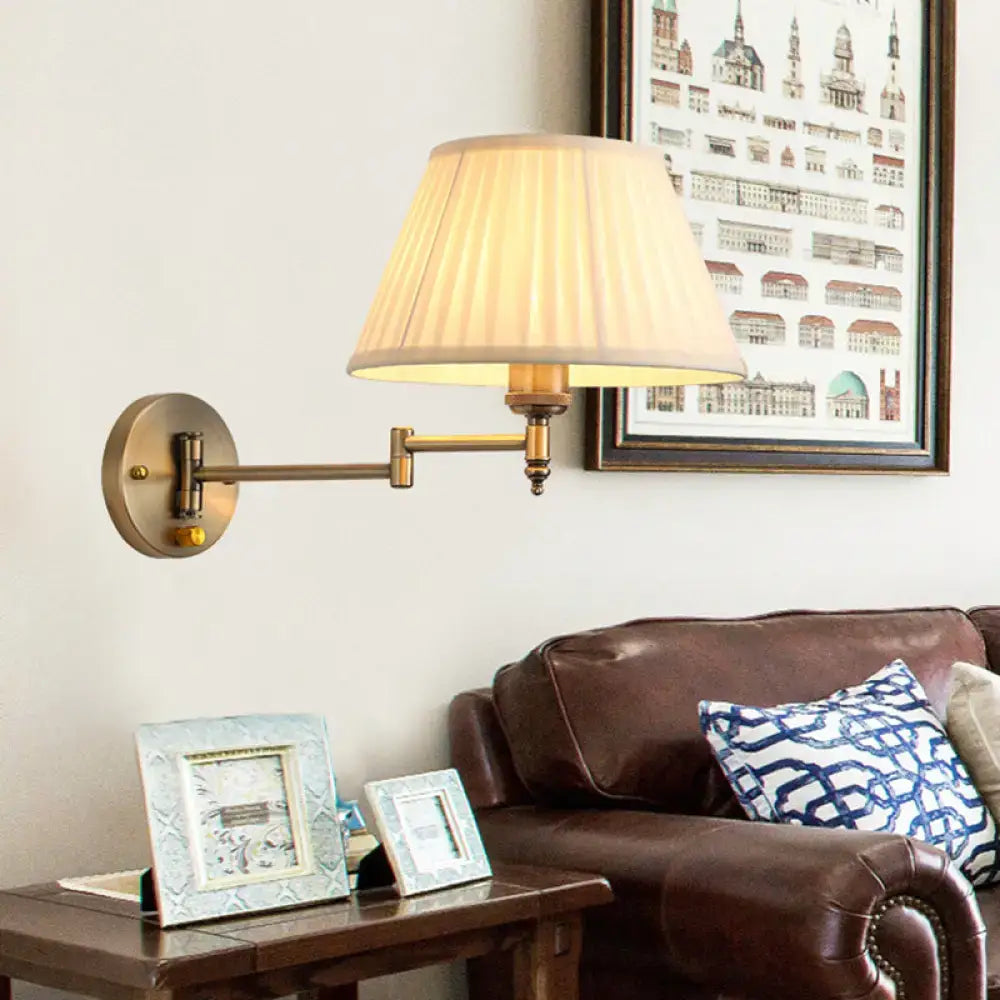 Modern brass swing arm paper wall mount lamp with cream pleated fabric shade for living room use