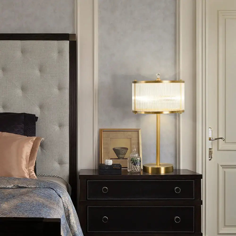 Gold-toned DecorBites™ modern brass nightstand lamp with clear glass rod drum shade and compatible 220v-240v 110v-120v bulb
