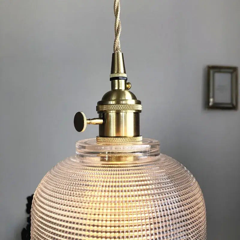 Modern brass textured glass led pendant light featuring a vintage brass finish and clear textured glass globe for kitchen use