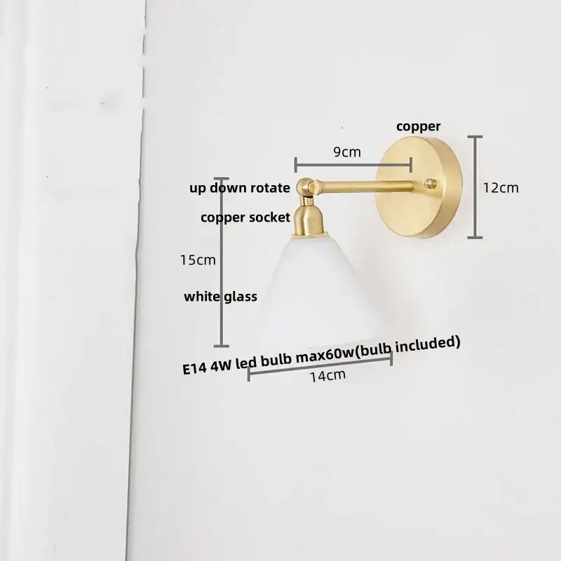 A modern brass wall lamp with a sleek copper sconce and decorbites clear glass shade for bedroom reading light