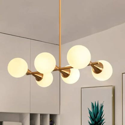 Modern brass-finished bubble island light fixture with five white bubble frosted glass globe shades by decorbites