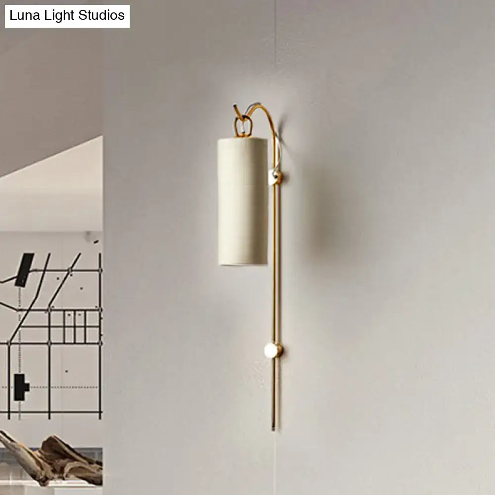 Modern brass and white wall sconce with cylindrical fabric shade and curved arm direct wired electric 220v-240v
