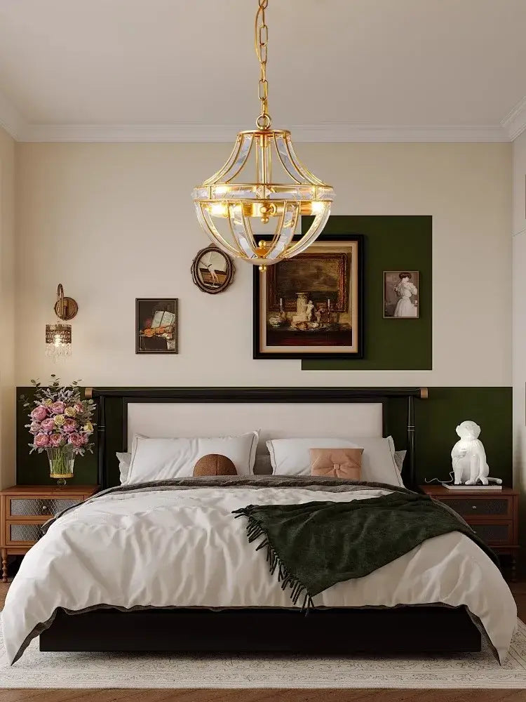 Gold-toned modern bronze black chrome gold globe LED chandelier with clear crystal accents hanging above bed decorbites bronze black