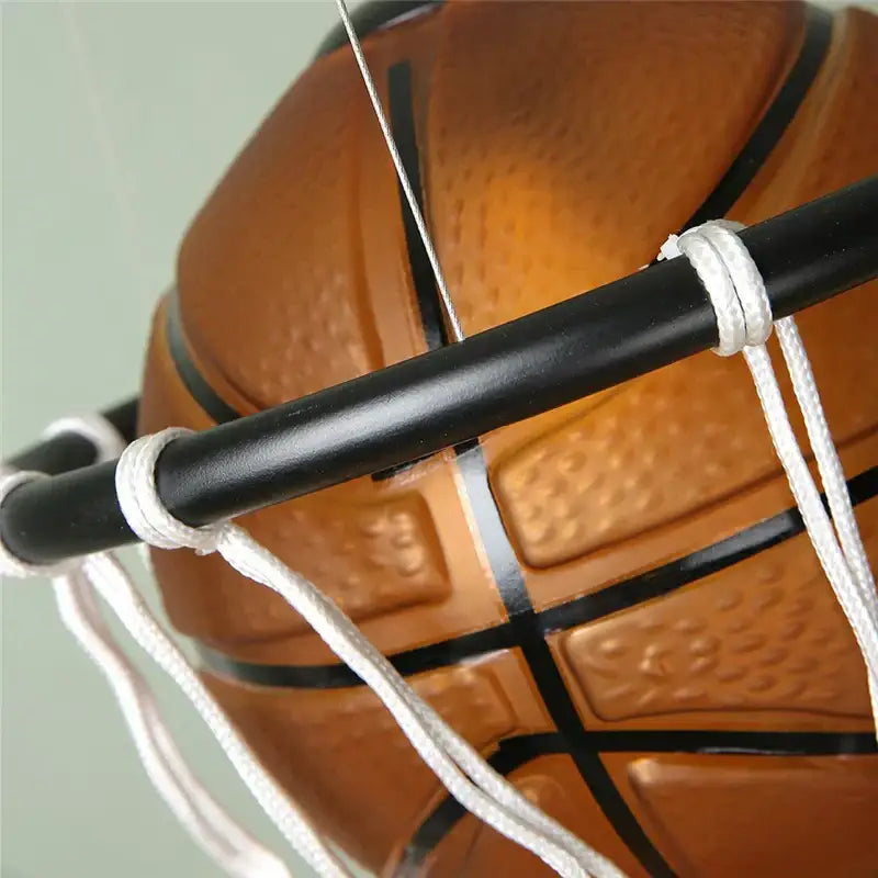 Modern brown basketball pendant lights featuring an orange basketball with black lines suspended in a white net decorbites basketball pendant