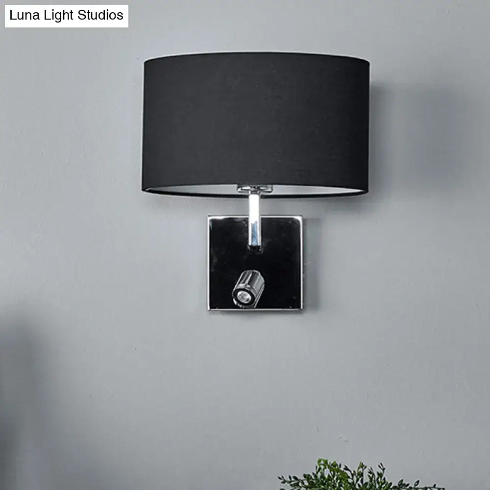 Modern brown fabric and chrome wall light with black cylindrical lampshade and adjustable spotlight for bedroom use