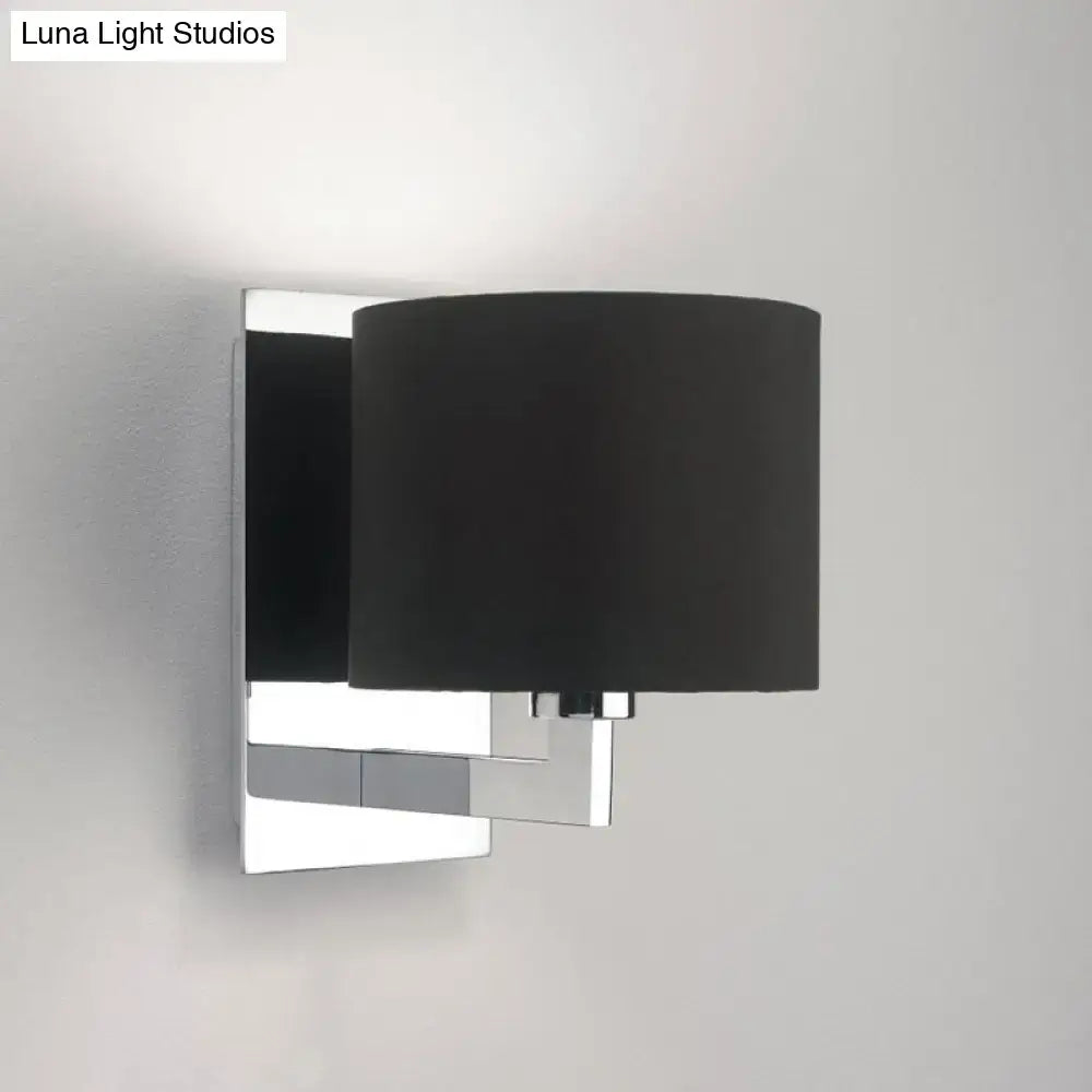 Modern brown fabric wall mount sconce with a sleek chrome metal frame and matte black cylindrical shade for bedroom lighting