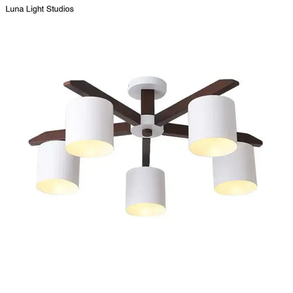 Modern brown and white ceiling mount chandelier with five white cylindrical shades and dark wood arms for living room