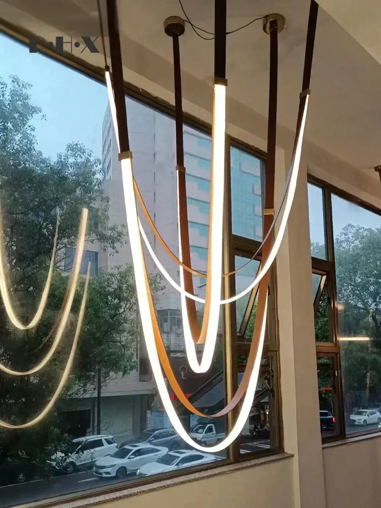 Modern brown and white decorbites designer belt light with warm white led strips and leather-like cords for dining room