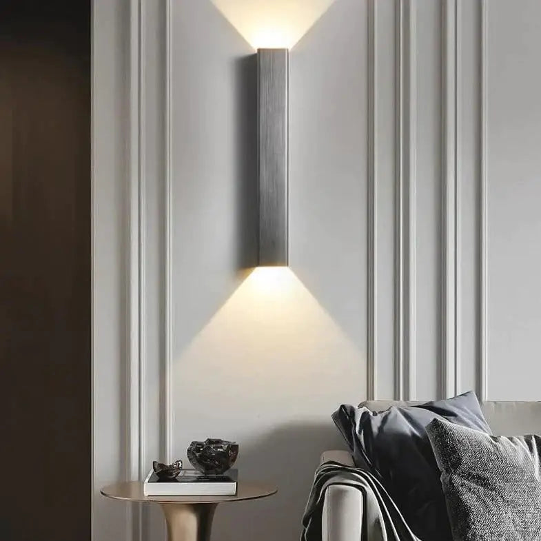 Modern brushed aluminum rectangular wall sconce with sleek metallic finish and two angled light beams for bedroom ambient light