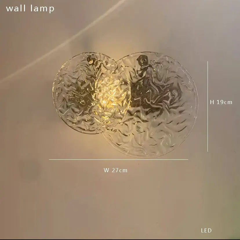 Modern brushed brass wall sconce lamps with clear textured glass and warm LED light for bedroom use