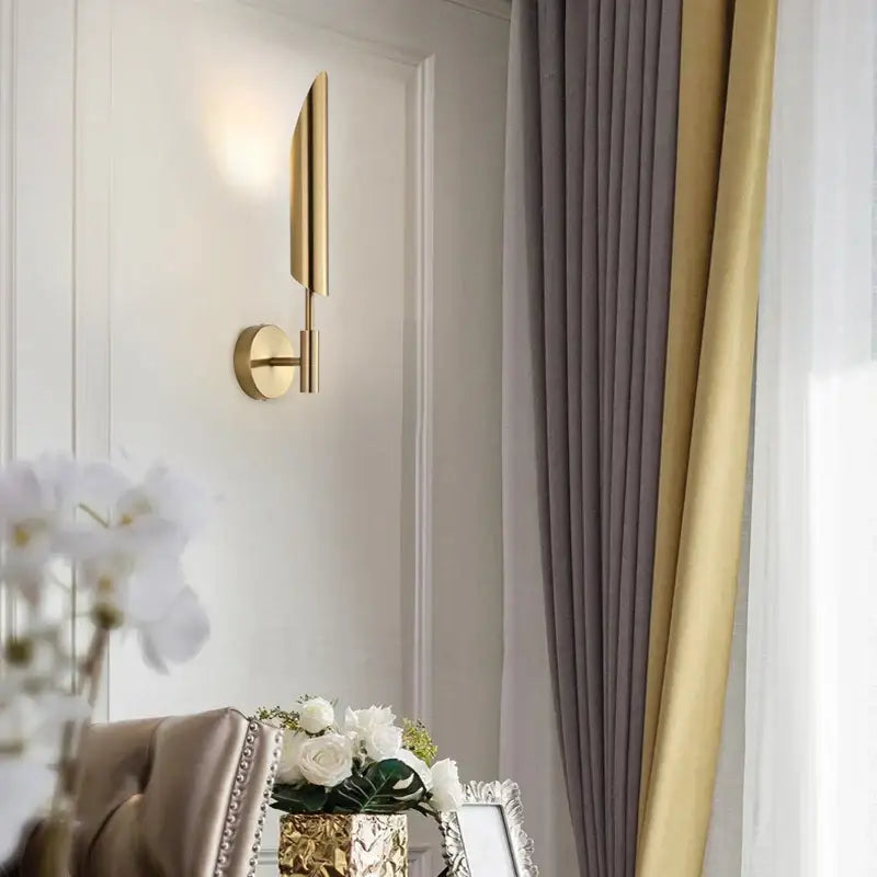 Modern brushed brass golden wall lamp showcasing a sleek gold-toned wall lamp for luxury bedroom decor by decorbites