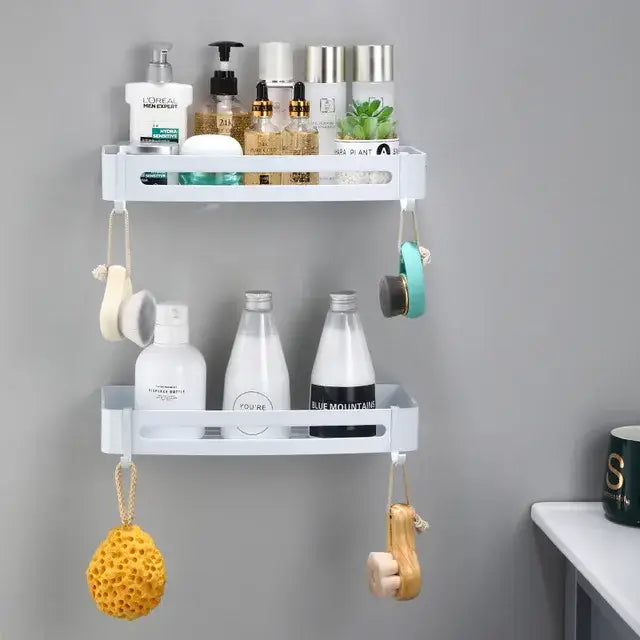 White plastic two-tier wall-mounted bathroom corner shelf with hanging hooks holding bath items by decorbites brushed gold aluminum