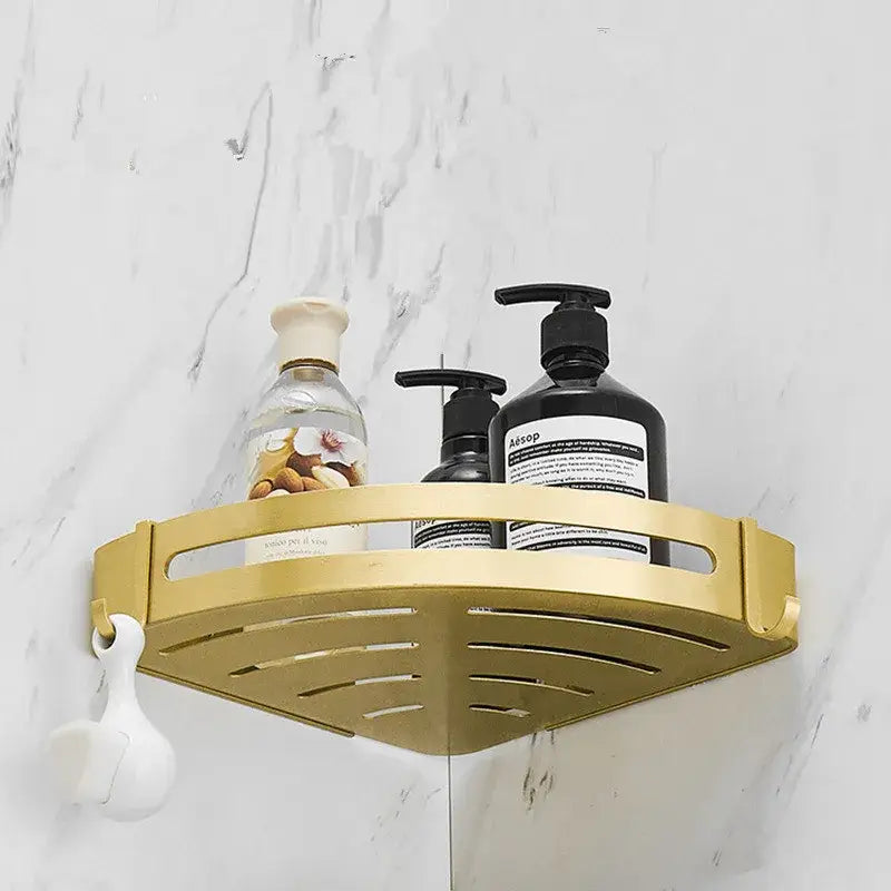 Modern brushed gold aluminum corner shelf with gold triangular slotted design and white plastic hook attachment by decorbites