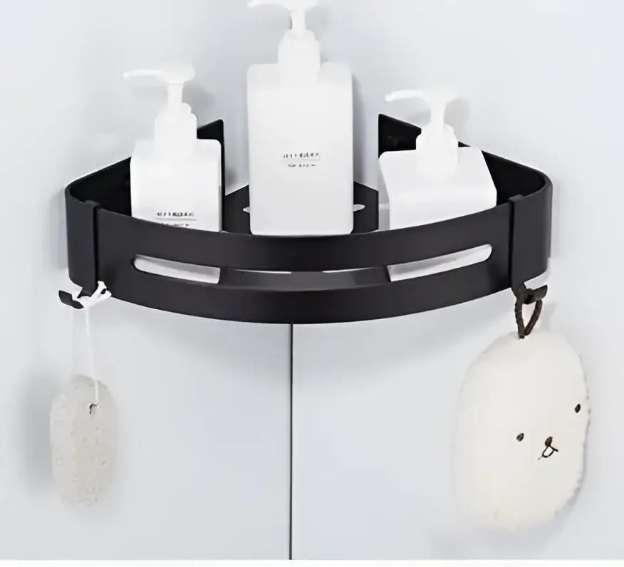 Modern brushed gold aluminum corner shelf with black metal shower caddy holding white bottles and plush scrubber