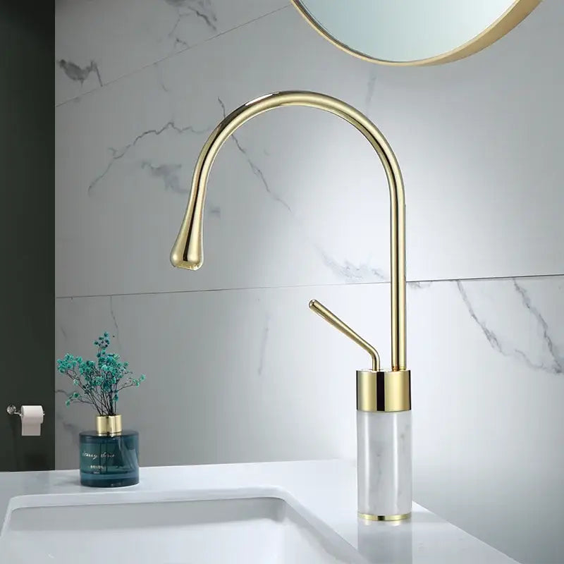 Modern brushed gold bathroom sink faucet with curved spout in brushed gold brass finish and marble base