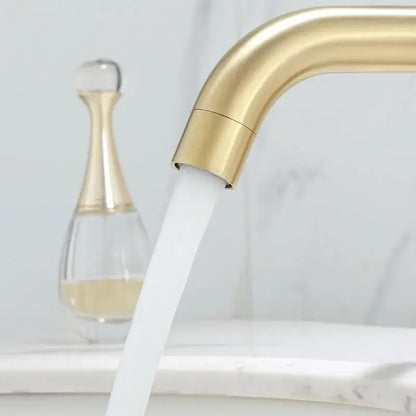 Modern brushed gold basin faucet with sleek curved design and flowing water stream from decorbites brushed gold collection