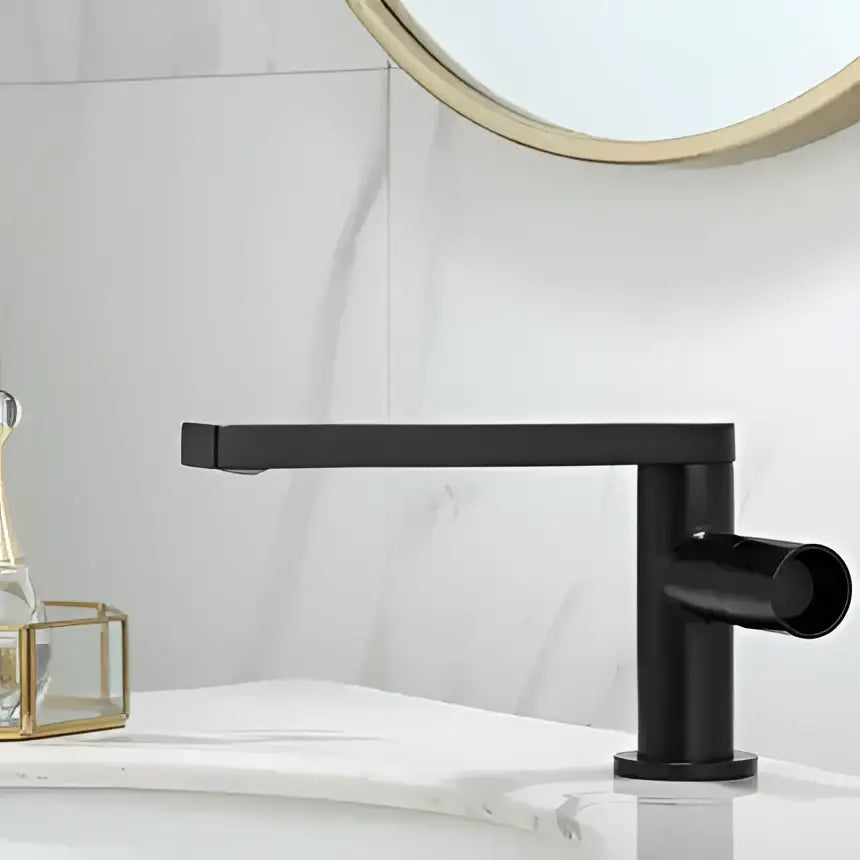 Black matte basin faucet with sleek rectangular spout and cylindrical handle complementing decorbites brushed gold style