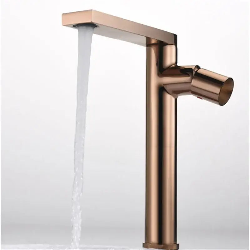 A sleek modern basin faucet with a tall rectangular spout and cylindrical handle in brushed gold decorbites finish