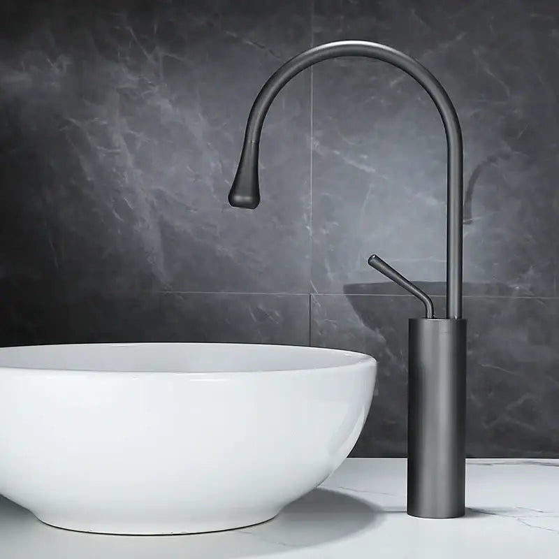 Modern matte black basin faucet with sleek curved spout and cylindrical base complementing decorbites brushed gold design
