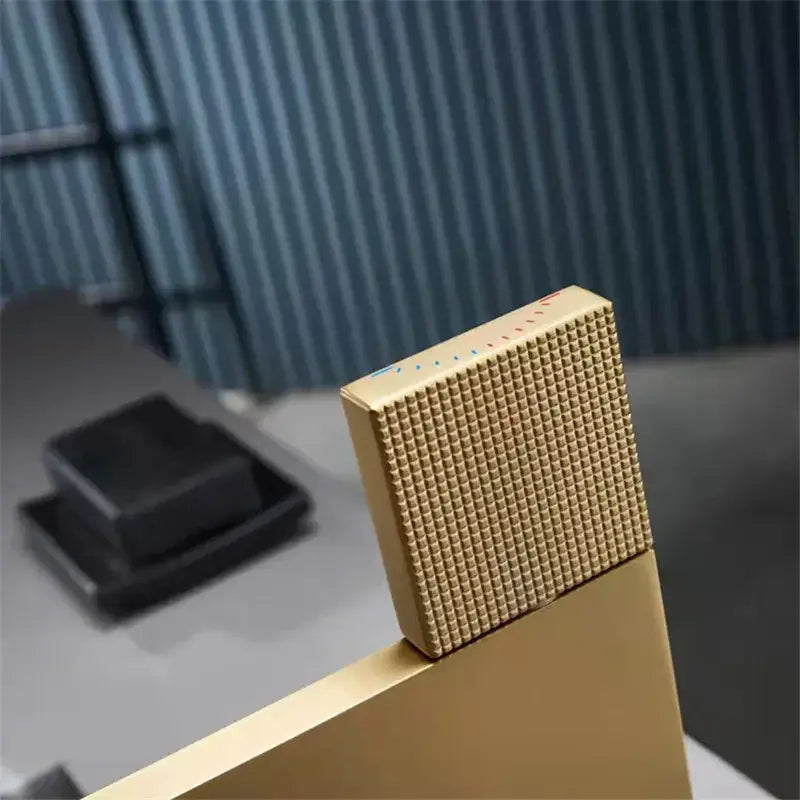 Modern brushed gold basin faucet handle with textured square design and subtle colored markings by decorbites brushed gold