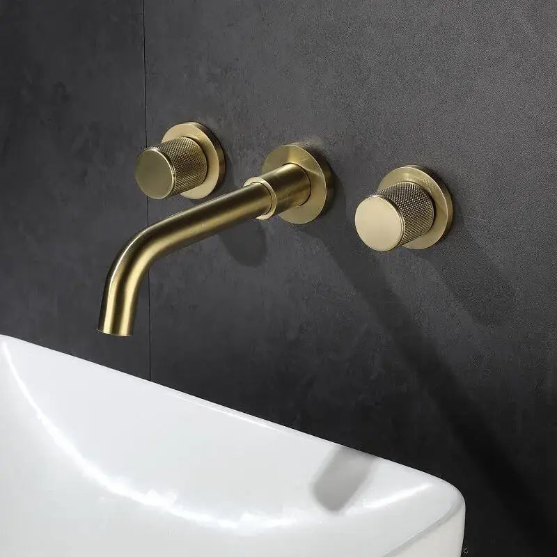 Brass-finished wall-mounted basin faucet with brushed gold textured circular handles and sleek curved spout decorbites brushed gold