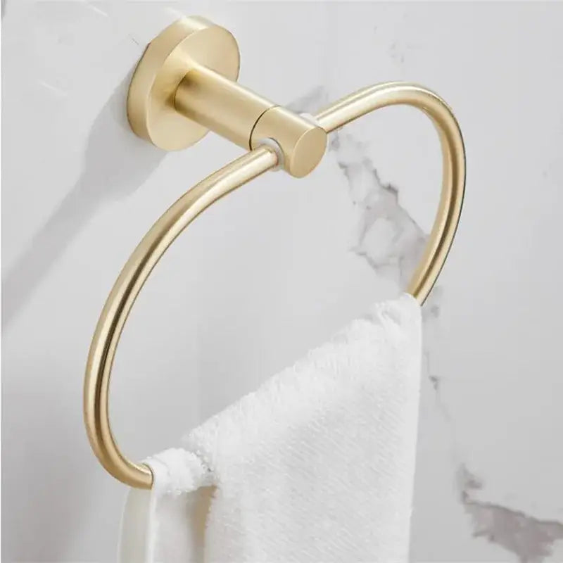 Modern brushed gold bathroom hardware set featuring a gold-toned metal towel ring with sleek circular design mounted on wall