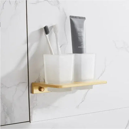 Minimalist wall-mounted toothbrush holder with two frosted glass cups and brushed gold metal base from decorbites bathroom set