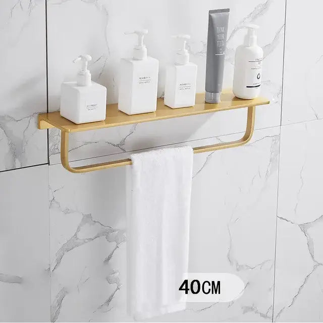Modern brushed gold bathroom set metal shelf with integrated towel bar holding white and gray pump bottles decorbites brushed gold