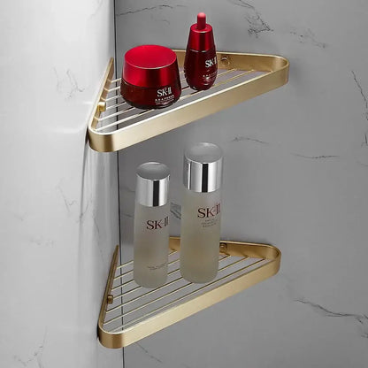 Modern brushed gold brass bath hardware set featuring a gold triangular wire mesh shelf holding sk-ii skincare products
