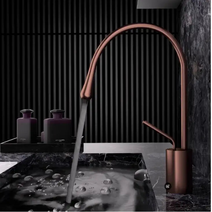 Modern brushed gold brass kitchen sink tap with copper-finished sleek curved spout and minimalist design