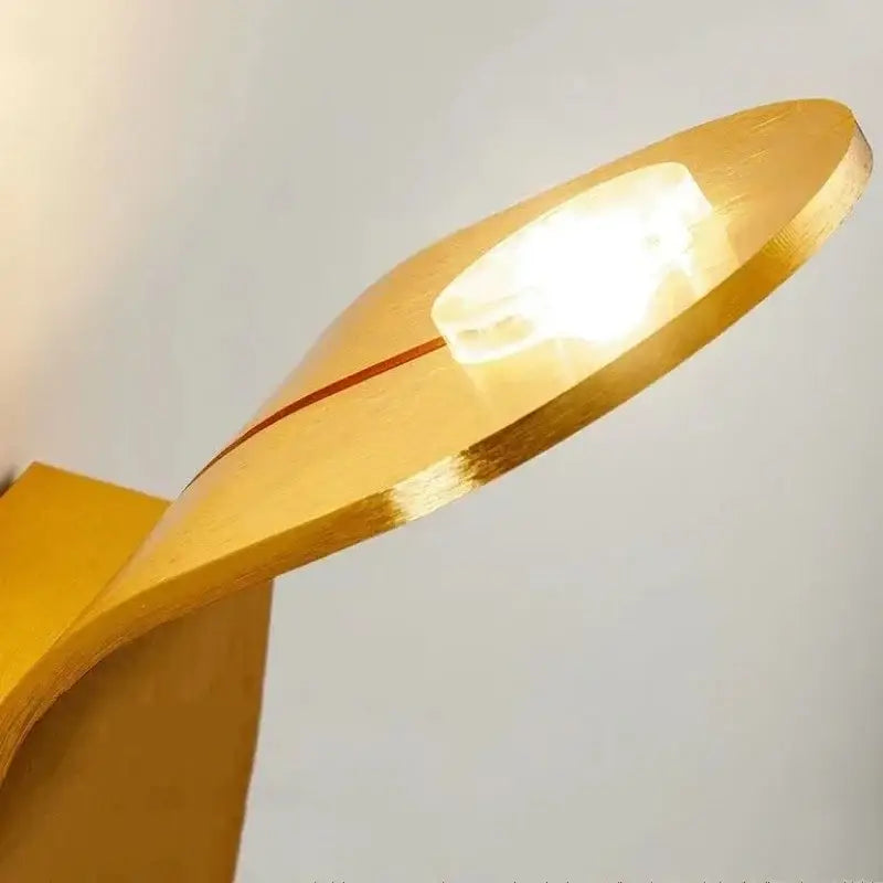 Modern brushed gold led wall lamp with sleek curved design emitting warm glow for living room use