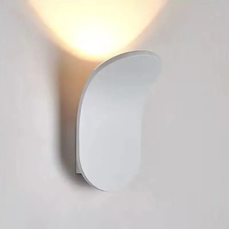 Modern brushed gold led wall lamp with a sleek curved white sconce emitting warm light for living room use