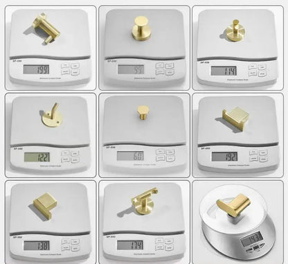 Modern brushed gold stainless steel robe hook with various gold-colored brass hardware pieces for cabinetry and furniture