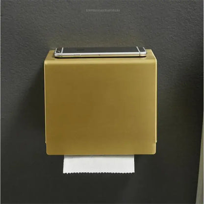 Modern brushed gold wall-mounted toilet paper holder with sleek rectangular design and a silver smartphone on top