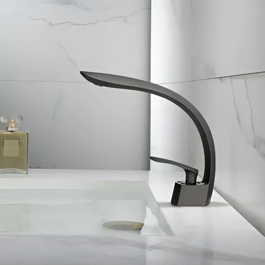 Modern matte black basin faucet with sleek curved design complementing decorbites brushed gold basin aesthetic