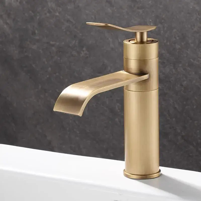 Brass-finished modern waterfall basin mixer with sleek cylindrical body and curved spout for bronze bathroom sink decorbites