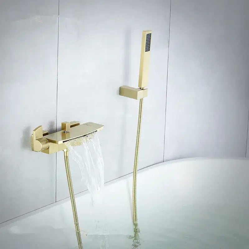 Modern brushed gold waterfall shower faucet set featuring a gold-toned bathtub faucet and matching handheld showerhead