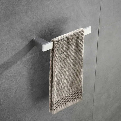 Modern brushed nickel bathroom hardware set with glass accents holding a beige textured towel on a chrome rack