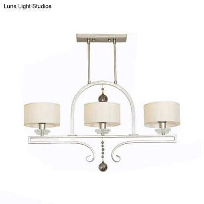 Modern brushed nickel island pendant light with silver-toned metal, cream fabric shades, and decorative crystal accents