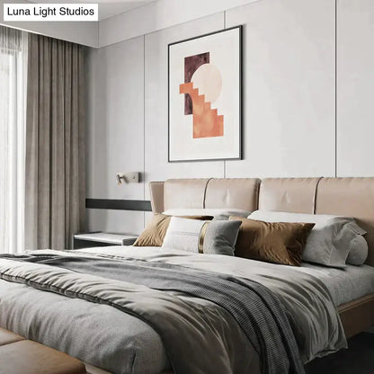 Beige upholstered bed with tufted headboard and neutral pillows featuring modern brushed nickel led dimmable reading wall light