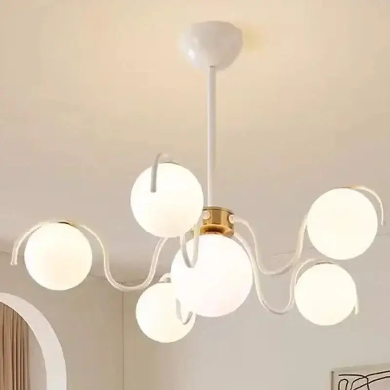 Modern white spherical globe pendant light with rounded glass arms and brass hub for dining room lighting
