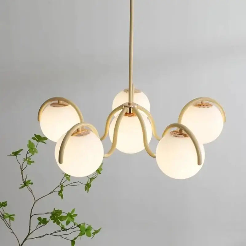 Modern brass-finished pendant light with five frosted rounded glass globe shades for dining room use