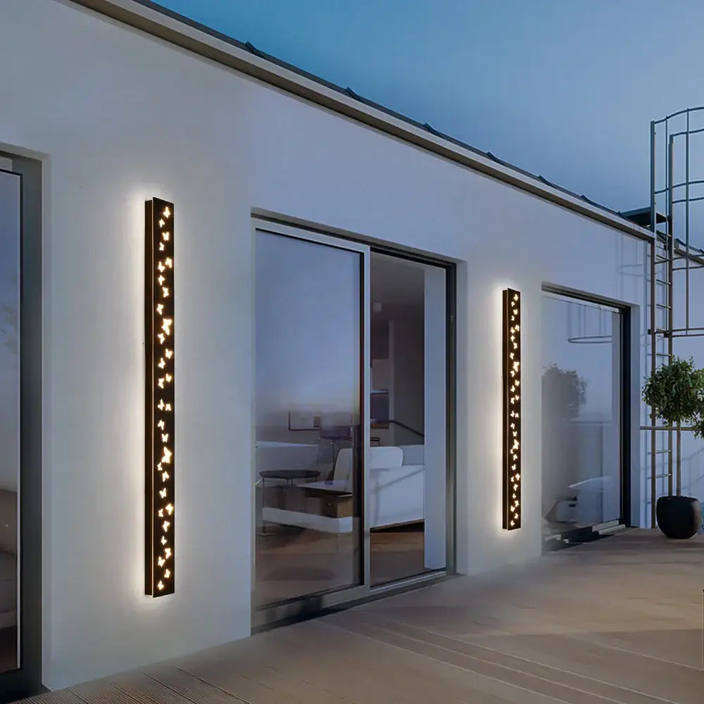 Modern black butterfly pattern led outdoor wall sconce with warm glowing vertical lights by decorbites