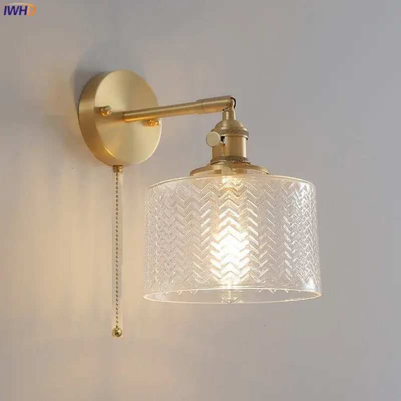 Gold-toned wall light with clear green glass led shade embossed with chevron pattern and pull-chain switch for bedroom use
