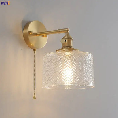 Gold-toned wall light with clear green glass led shade embossed with chevron pattern and pull-chain switch for bedroom use