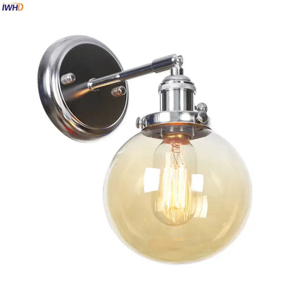 Modern chrome wall light with amber glass ball and exposed filament bulb for bedroom sconce lighting