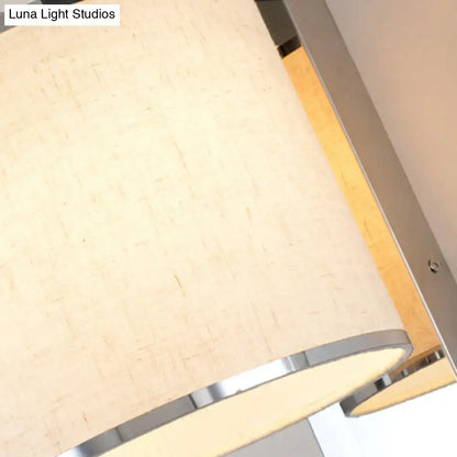 Beige textured fabric lampshade with sleek chrome rim on modern LED living room wall sconce light fixture